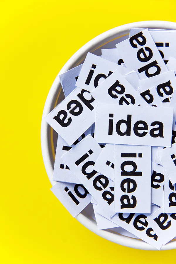 Paper with the word idea in a bowl on a yellow background, representing creativity in graphic design and branding.