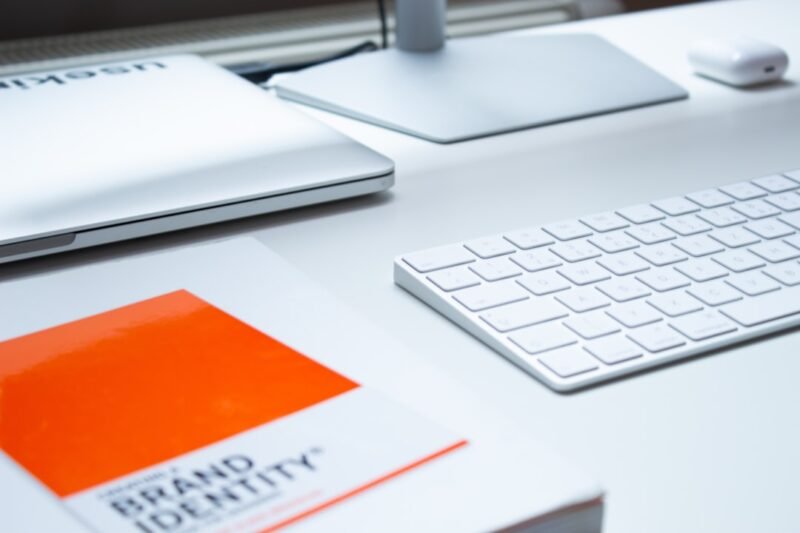 Keyboard and book on brand identity, key elements in graphic design. Modern minimalist desk.